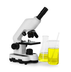 Laboratory glassware with yellow liquid and microscope isolated on white