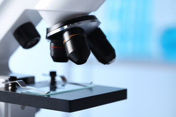Microscope with glass slide in laboratory, closeup. Space for text