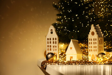 Fototapeta na wymiar Beautiful decorative houses and small Christmas tree on window sill indoors. Space for text