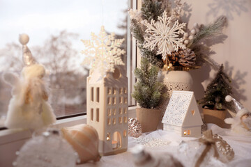 Many beautiful Christmas decorations and fir branches on window sill indoors