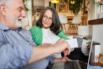 Paar Senioren mit Kreditkarte beim Online-Shopping