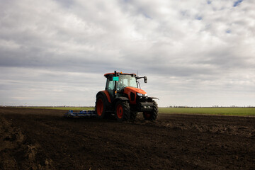 Obraz premium Tractor is preparing the land at dusk