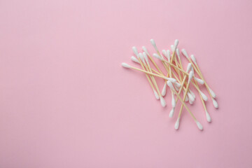 Heap of wooden cotton buds on pink background, flat lay. Space for text