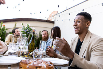 Family and friends celebrating at dinner on a rooftop terrace