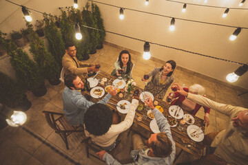 Family and friends celebrating at dinner on a rooftop terrace