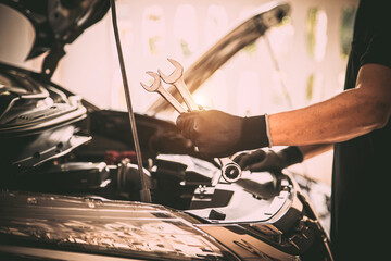 Close-up hand auto mechanic using the wrench to repairing car engine problem. Concepts of check and fix car and maintenance servicing.