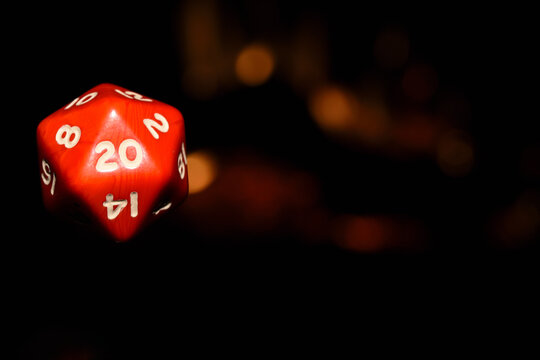 Dado de 20 caras rojo con fondo negro y fuego