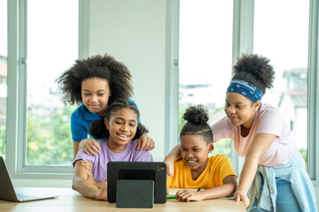 Happy school children having lesson at elementary stem class sitting at desks using digital tablet.
