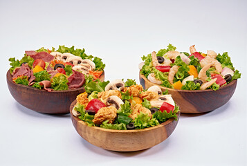 shrimp, chicken, and beef salad on a wooden bowl on isolated white background