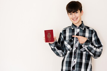 Young teenager boy holding Serbia passport looking positive and happy standing and smiling with a...