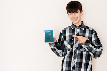 Young teenager boy holding Taiwan passport looking positive and happy standing and smiling with a confident smile against white background.