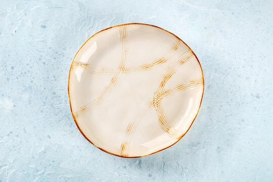 An empty plate with a gold rim, overhead flat lay shot on a slate background, the concept of food
