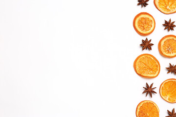 Dry orange slices and anise stars on white background, flat lay. Space for text