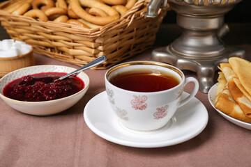 Aromatic tea and cherry jam on table