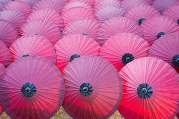 Beautiful red color of paper umbrella Traditional handmade umbrella a product that is unique and popular as a souvenir for tourists in travel of Chiang Mai, Northern Thailand.