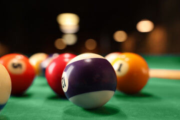 Many colorful billiard balls on green table, closeup