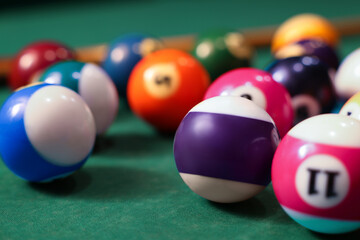 Many colorful billiard balls on green table, closeup