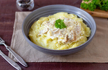 Mashed potatoes with meat and sauce in a gray plate.