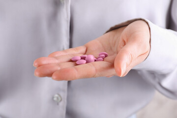 Obraz na płótnie Canvas Woman holding pile of pink antidepressants, closeup view