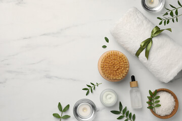Flat lay composition with different spa products on white marble table. Space for text