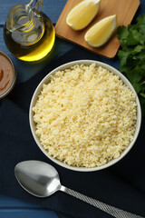Tasty couscous and ingredients on blue wooden table, flat lay