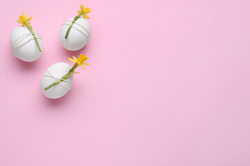Easter eggs decorated with flowers on pink background, flat lay. Space for text