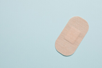 Contraceptive patch on light blue background, top view. Space for text