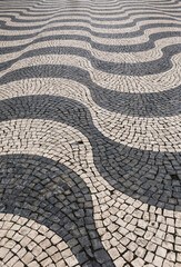 Naklejka premium Beautiful Cobblestone pavement forming waves in Lisbon
