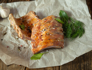 Smoked pork ribs with spices and fresh herbs, on the table, top view,