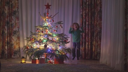 Excited little boy near Christmas tree