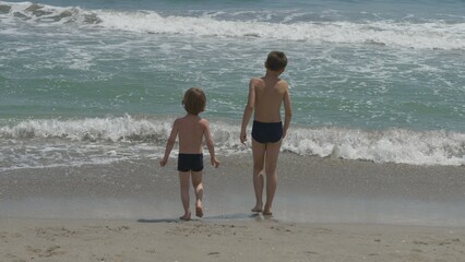 Children play with waves, go back and forth, summer and joy time