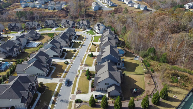 Row of new developments houses in master planned subdivision with lush green trees and natural trails outside Atlanta, Georgia, USA