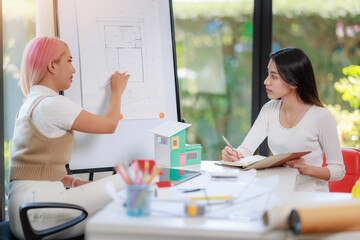 Obraz premium Construction and architect home building company concept, Engineers, architects and designers work together to design home or resident housing and validate blueprints in the workplace.