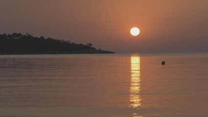 Sunrise reflected in the sea near the coast of the island