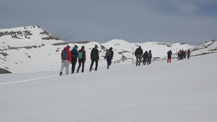 Tourists trekking in the snow on top of the mountains