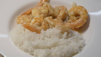 Serving rice and prawns with wine and lemon sauce