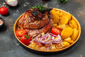 Whole cooked pork neck with baked potatoes. Pork leg done, German food. place for text, top view