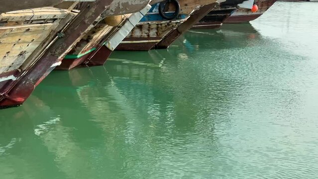 Wooden Boat Old sailing in Qatar and group of fish jump shallow surface of green sea water in the bay in day time in Doha Qatar.
Fishing sailing local skill and traditional Dhow Lenj arabian heritage