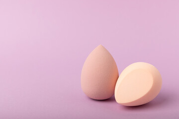 Beauty blender. Colorful beauty sponges on a lilac background. Cosmetic tool for applying foundation, concealer. Place for text. Place to copy.