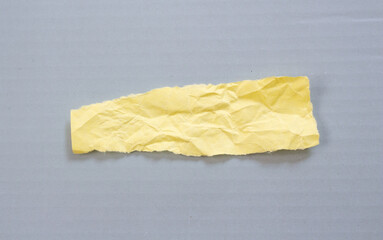 Ripped paper on grey background. Torn paper piece with copy space for text.