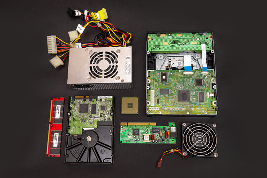 Disassembled computer parts recycled: hard disk drive (hdd), ram stick, fan, power supply unit (psu), graphics processing unit (gpu), central processing unit (cpu). 