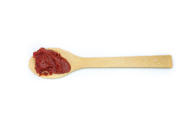 Wooden spoon with tomato paste on a white background. Top view, flat lay.