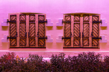 Vintage sliding wooden shutters with wrought iron bars.