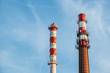 Boiler house chimney. Two towers against the clear blue sky. Industrial zone of the city.