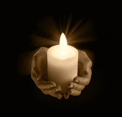 Women's hands holding a candle