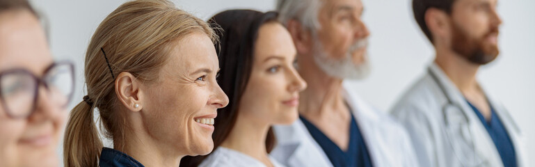 Group of professional doctors standing in a line at the modern clinic