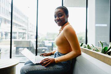 African female student working on computer in public place