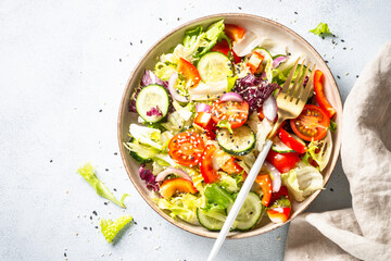 Fresh salad with green leaves, cucumber, paprika and tomatoes. Flat lay.