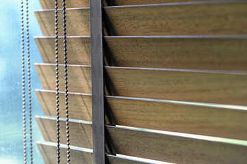 Close-up brown wooden blinds. lighting range control sunlight coming from a window. decoration interior. Modern jalousie.