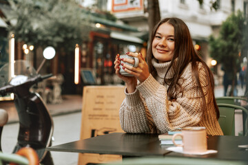 Stylish young woman drinking coffee at the coffee shop